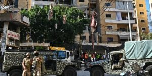 Soldados libaneses montam guarda enquanto equipes de resgate inspecionam os dano