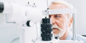 Senior patient checking vision with special eye equipment