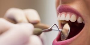 dentist-examining-female-patient-with-tools-1024x683.jpg
