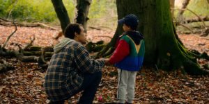 Imagem colorida mostra Jordan Bolger como André Hanscombe, Jahsaiah Williams com